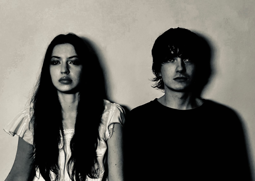 Members of the band Witch Post leaning against a wall in black and white.x